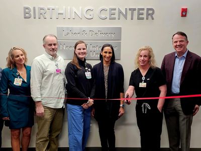 A group of hospital staff smile during the recent ribbon cutting ceremony to open the new birthing center.