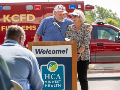 Elizabeth White smiles while receiving a hug during her reunion with her EMS care team.