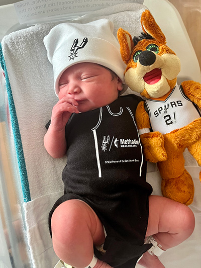A newborn wearing the first Spurs onesie.