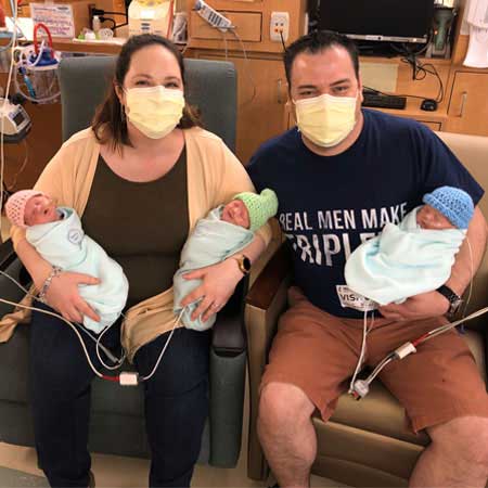 Evan and Lauren Wright holding their triplets.