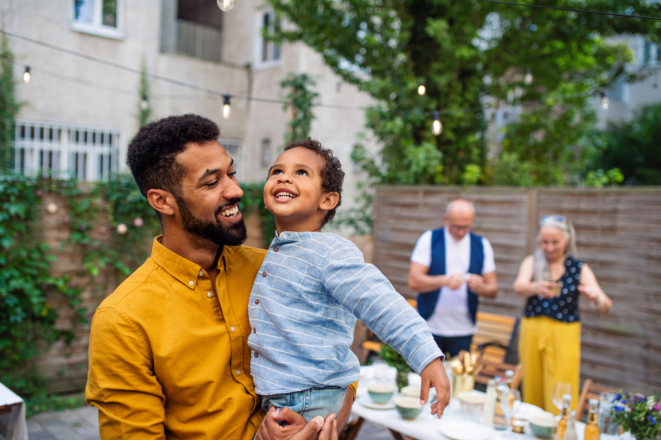 Man holding child at backyard barbeque