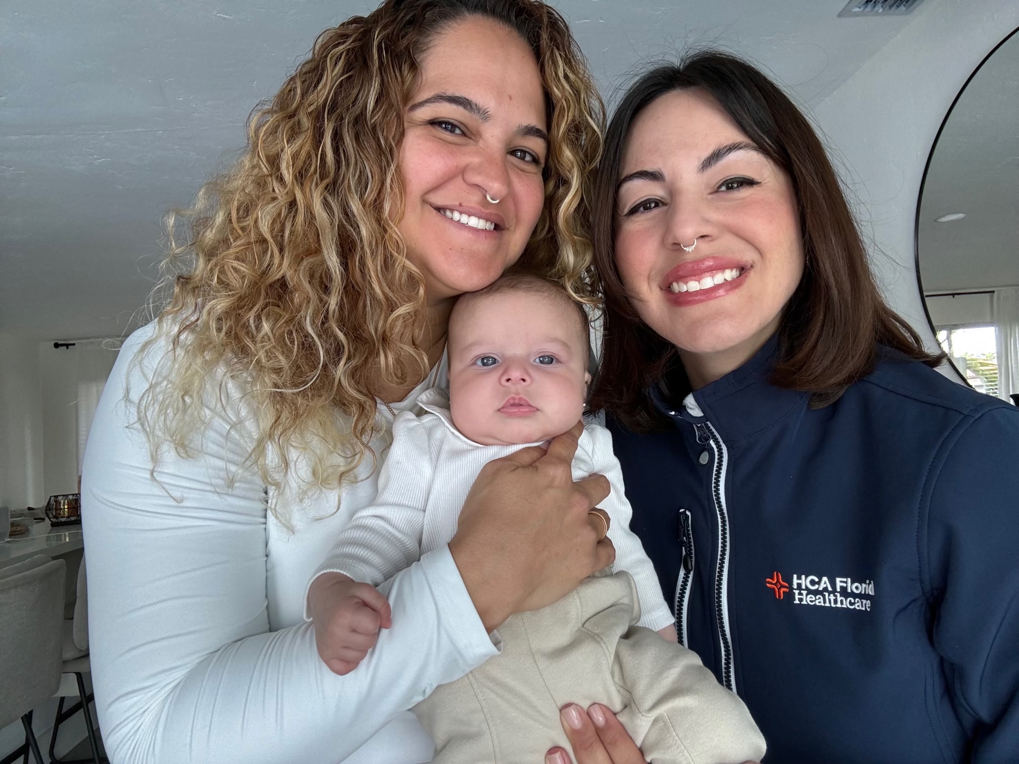 Yoiris Varela-Mora, her partner Liz, and their baby girl Olive pose for a picture.