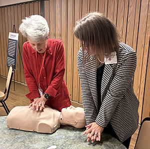 Women training CPR on mannequin
