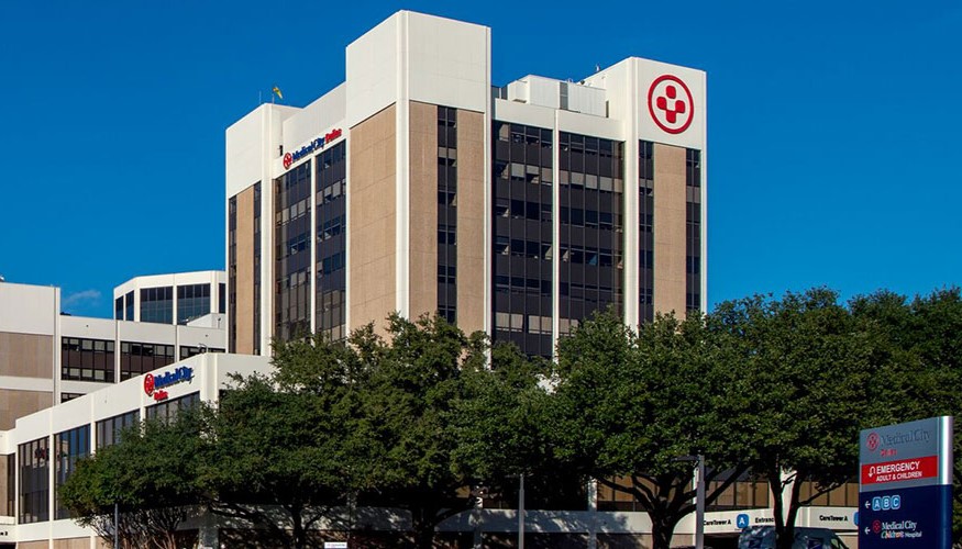 Exterior view of the main entrance to Medical City Dallas Hospital at twilight.