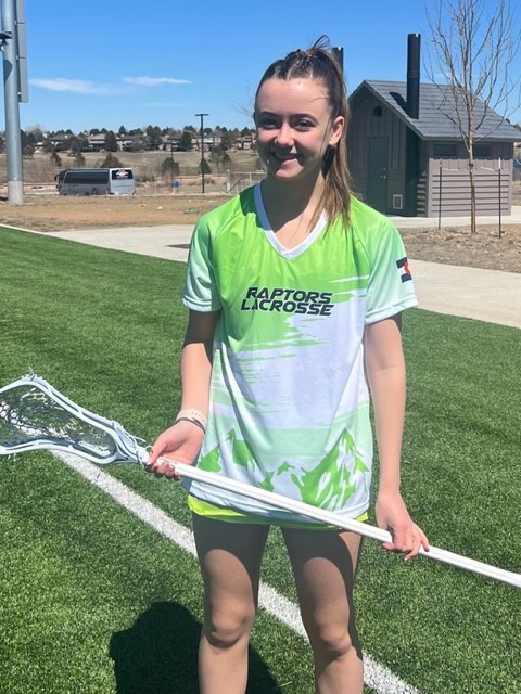 Addie Jenkins holding her lacrosse stick on the lacrosse field