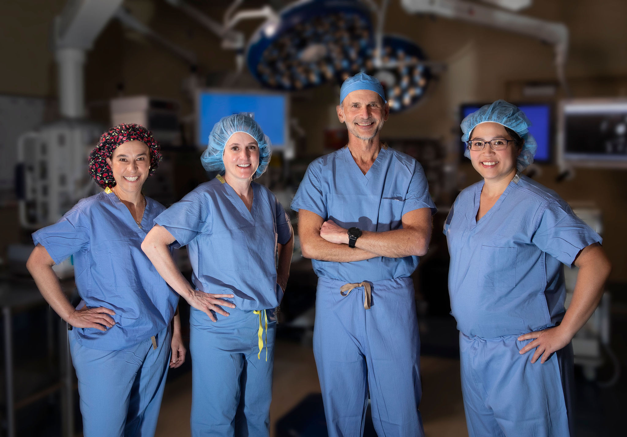 Dr. Rothenberg and three fellow surgeons wear scrubs in the OR