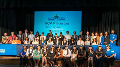 Clear Creek ISD students and administrators join HCA Houston Healthcare leaders for a group photo to commemorate Signing Day for 38 graduating students.
