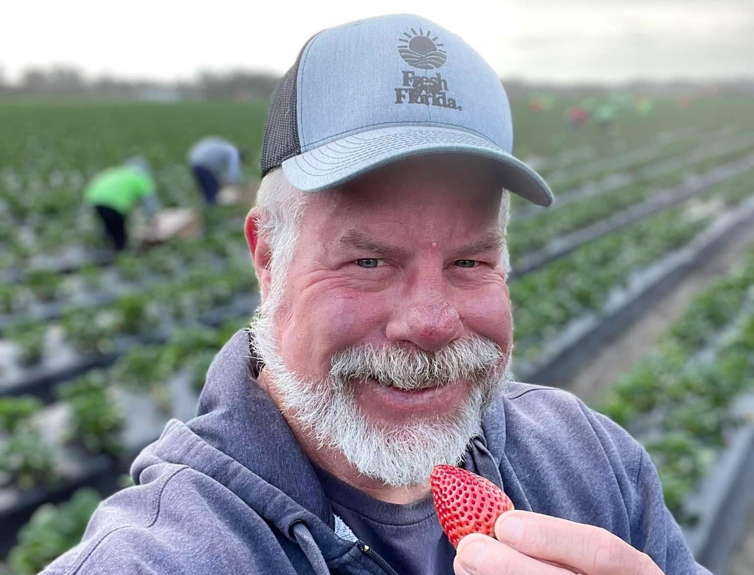 Jeff Blocker standing in a strawberry field smiling.