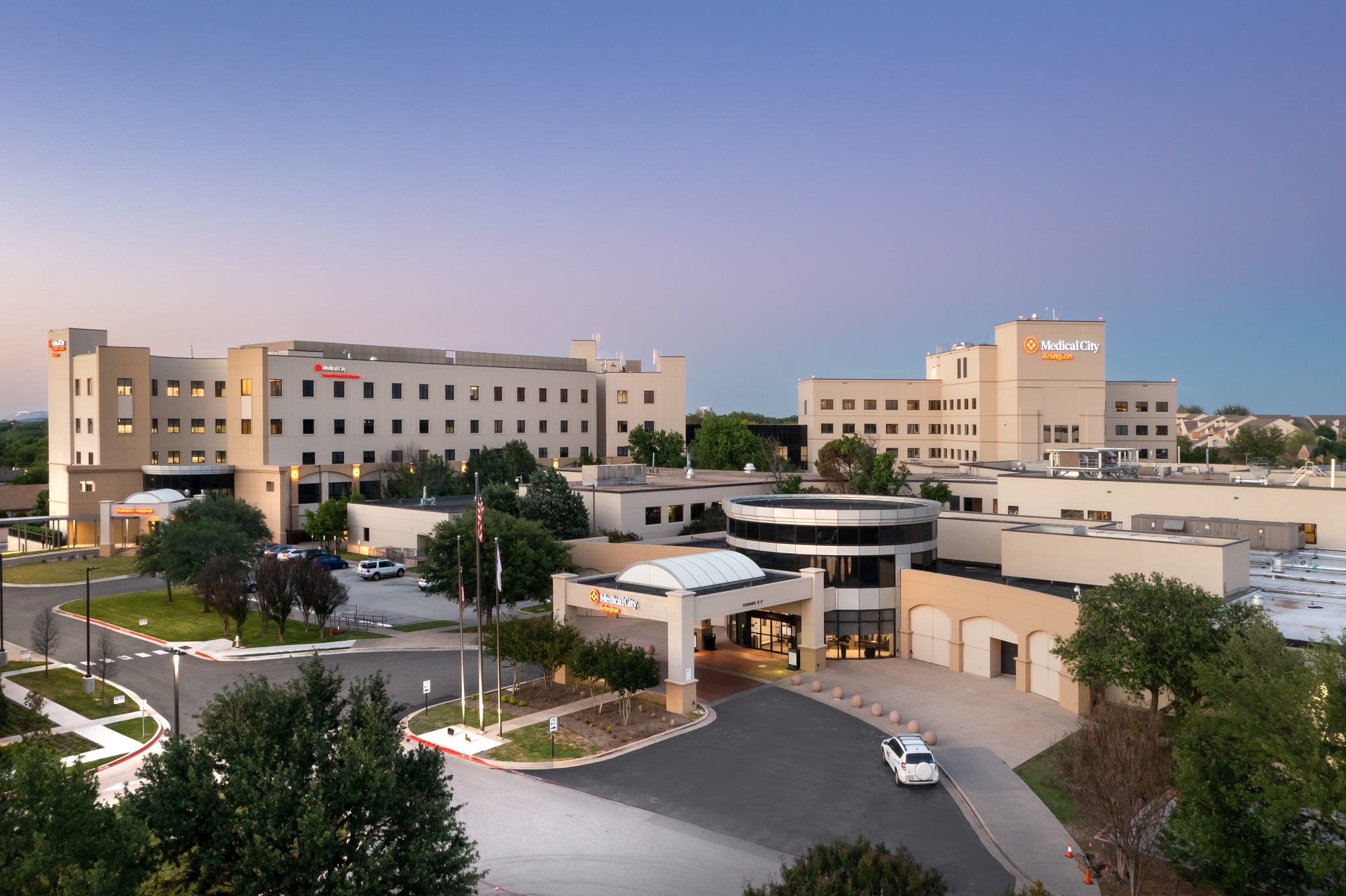 Exterior view of the main entrance to Medical City Arlington Hospital at dusk.
