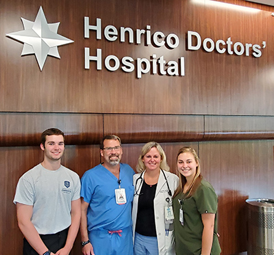 The Oliver Family, Will, William, Jeannie, and Emily, standing in front of a sign that says Henrico Doctors' Hospital.