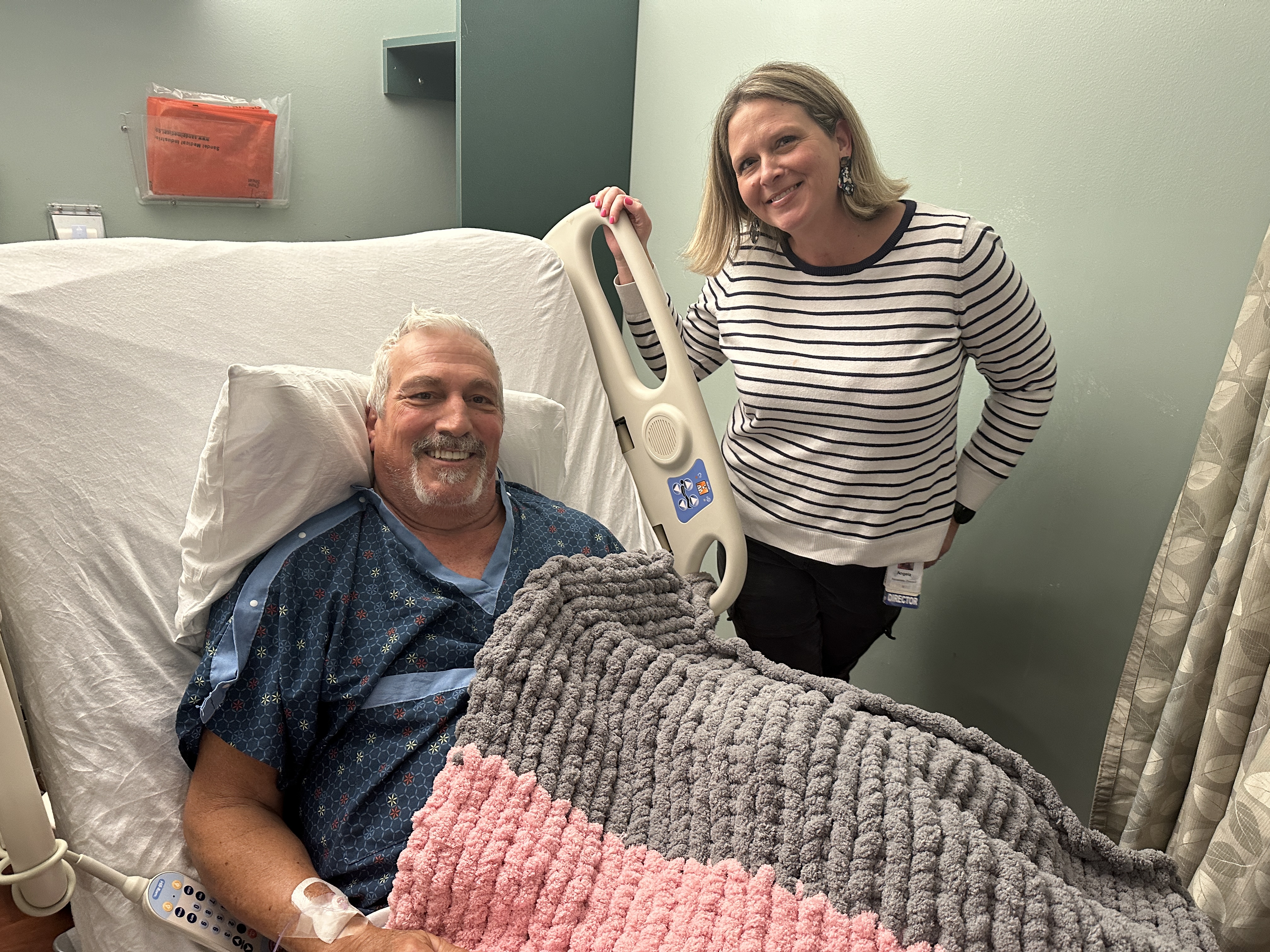Colleague poses with patient who she provided a handmade blanket to that she knitted for patients on Valentine's Day.