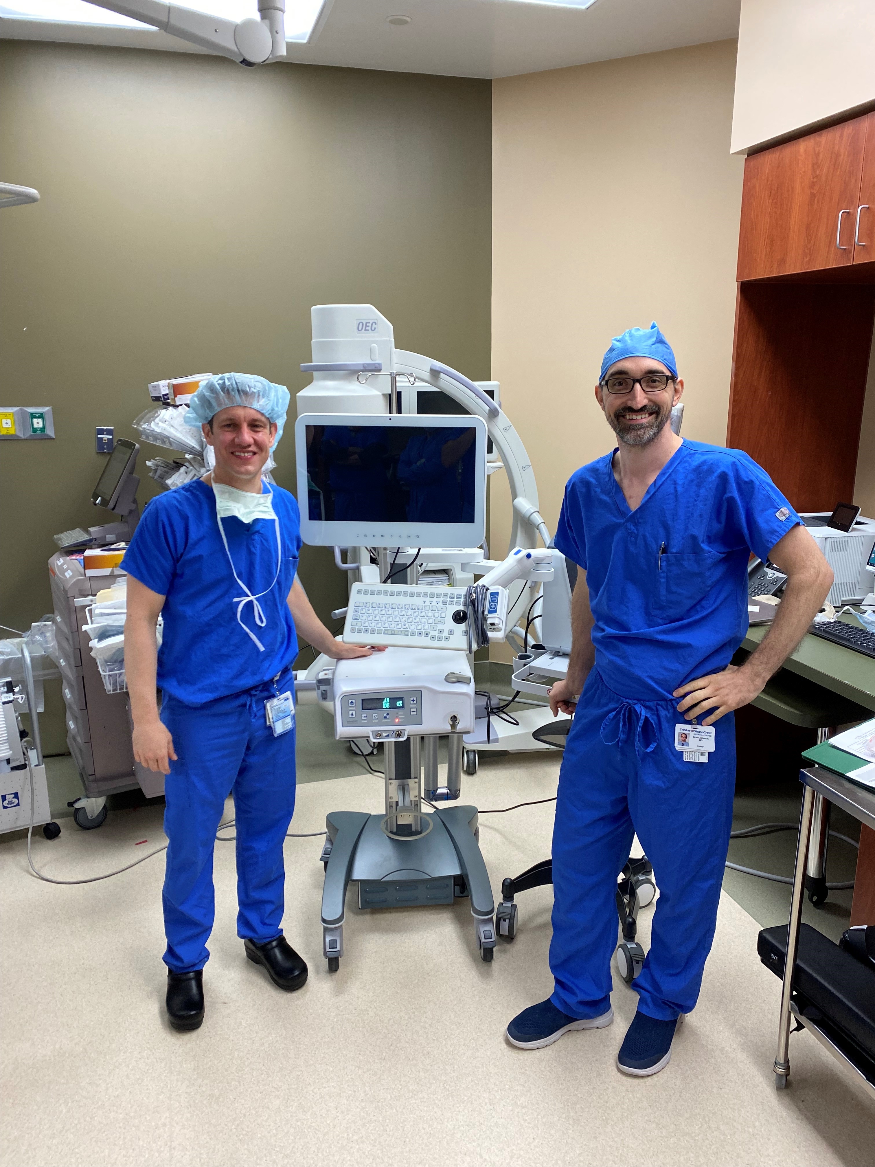 TriStar StoneCrest Urologists Dr. Grant Johnson and Dr. Alberic Rogman smile while standing in front of the aquablation device.