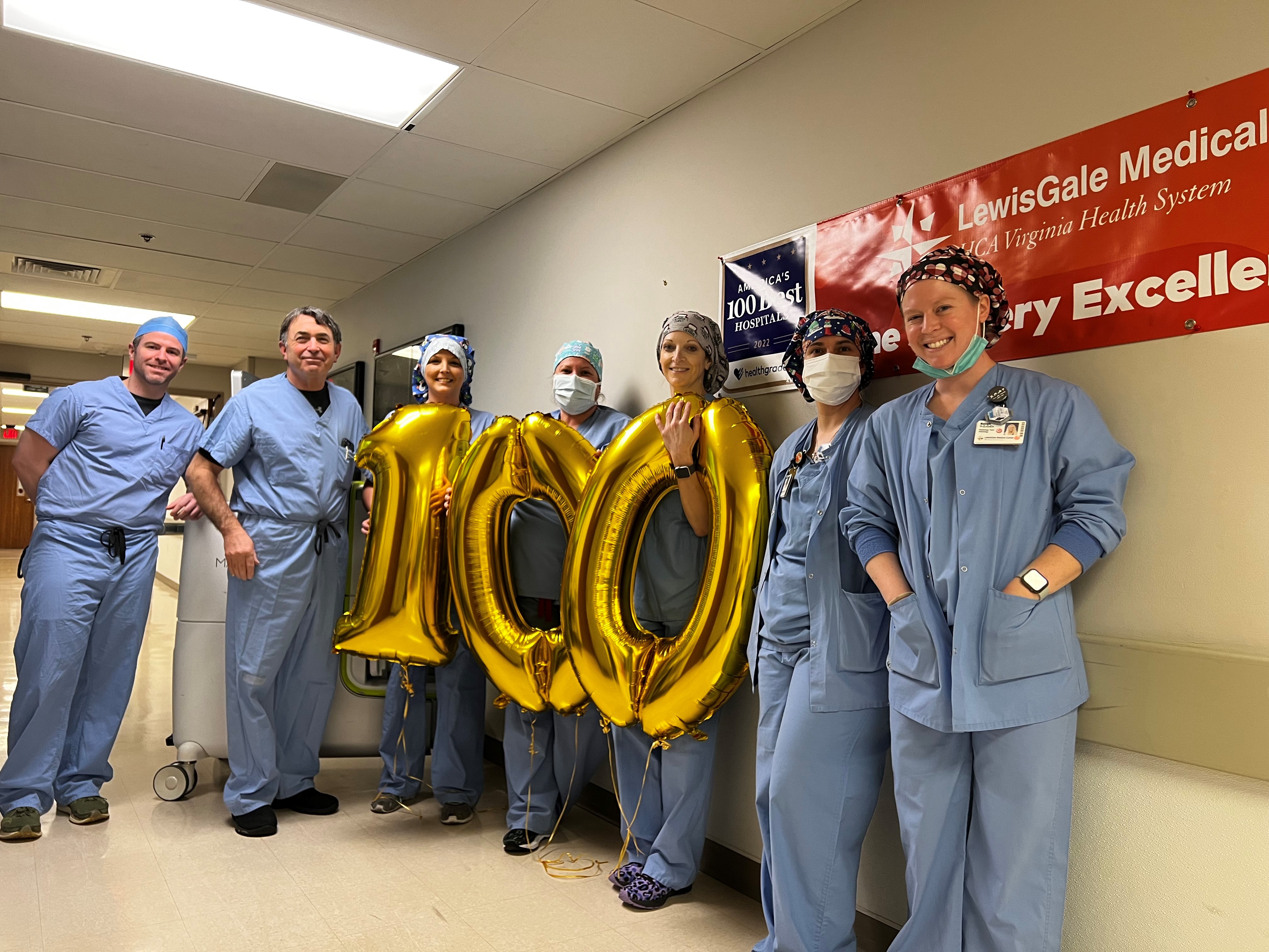 Robotic surgery team at LewisGale Medical Center joyfully hold a centennial gold balloon.