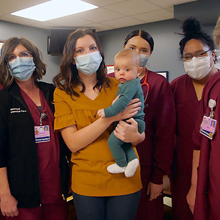 Teisha Walker holding her baby boy, surrounded by the NICU nurses.