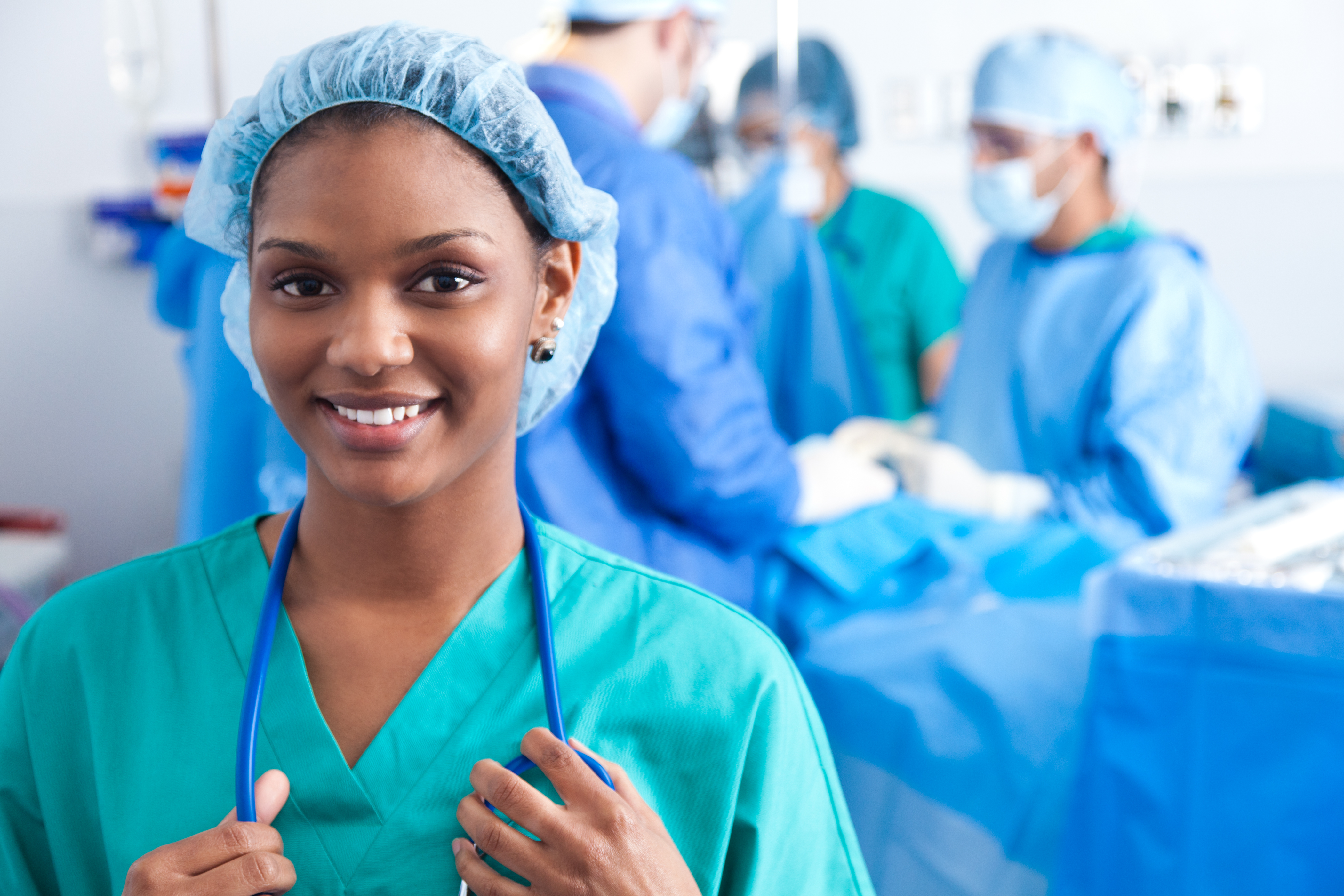 Operating room nurse in blue scrubs poses in operating room