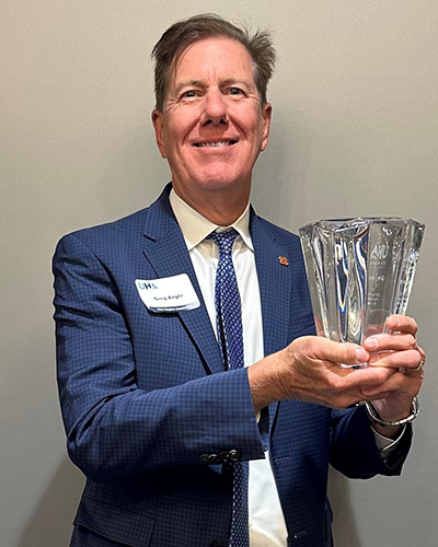 Greg Angle holds up his Distinguished Healthcare Executive Award.
