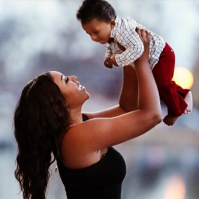Arika Hall holding her baby in the air.