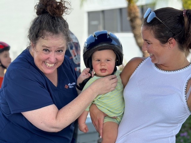 Debbie Wendt, RN, certified bicycle helmet fitter provides a personal fitting and helmet to a young community member  