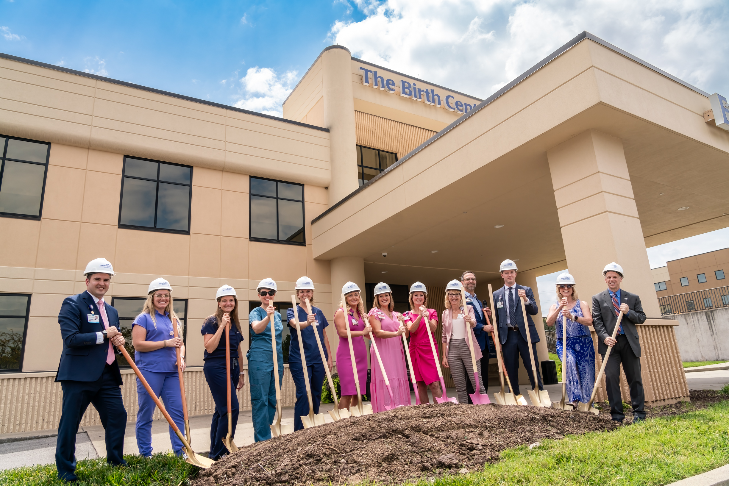 Tristar Hendersonville staff break ground with shovels and hardhats in the grass in front of the building