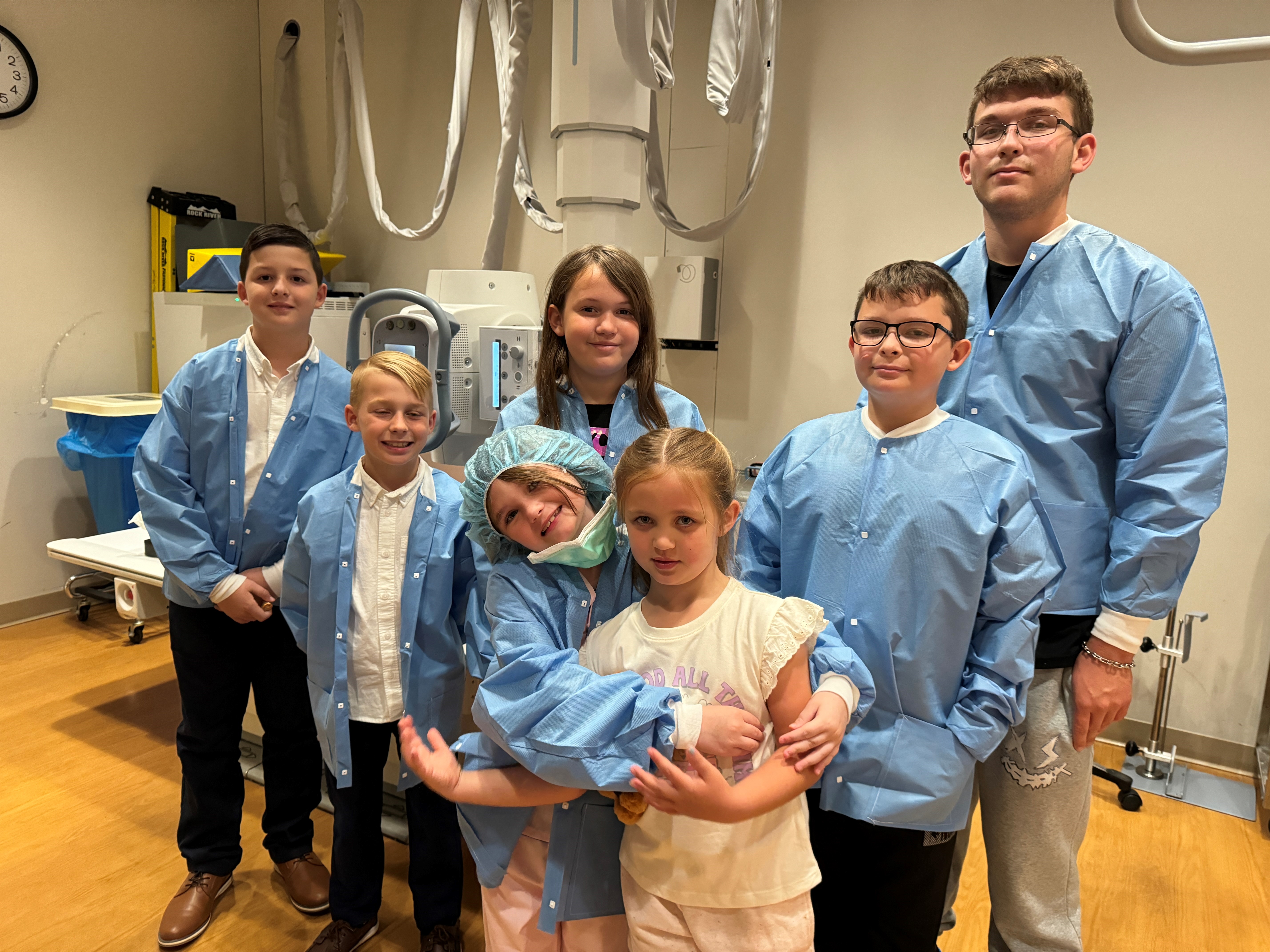 Photo of children standing in a hospital room.