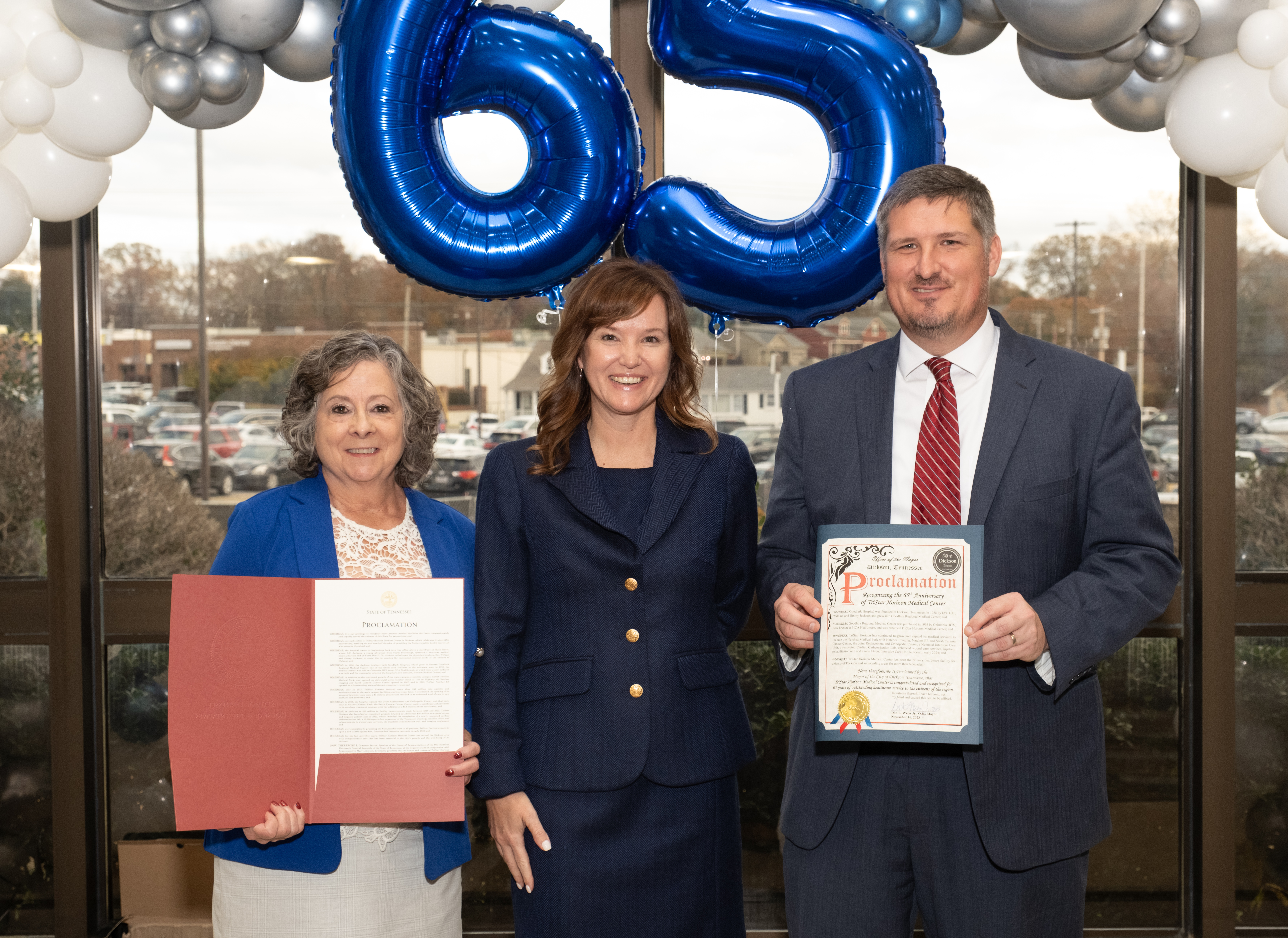 Mary Littleton (left) and Jason Epley (right) present hospital CEO, Cindy Bergmeier (center) with proclamation certificates