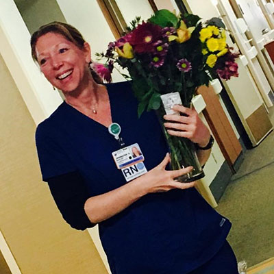 Nurse Jennifer Harlan holds a bouquet of flowers