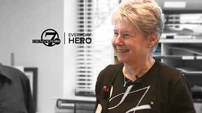 Linda Whitehouse smiles while volunteering at Sky Ridge Medical Center. The words, "Denver7 abc Everyday Hero" are also in the image.