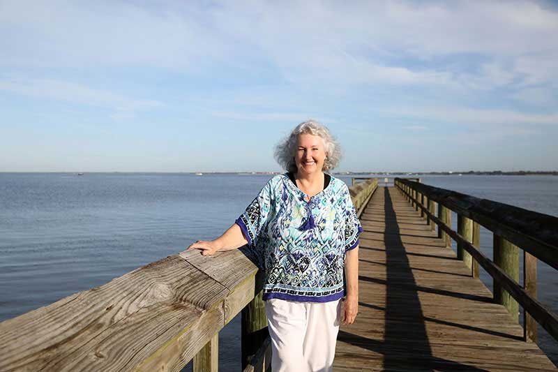 Linda Powell standing on a wooden pier