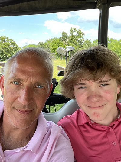Kent Long smiles while out golfing with his son.