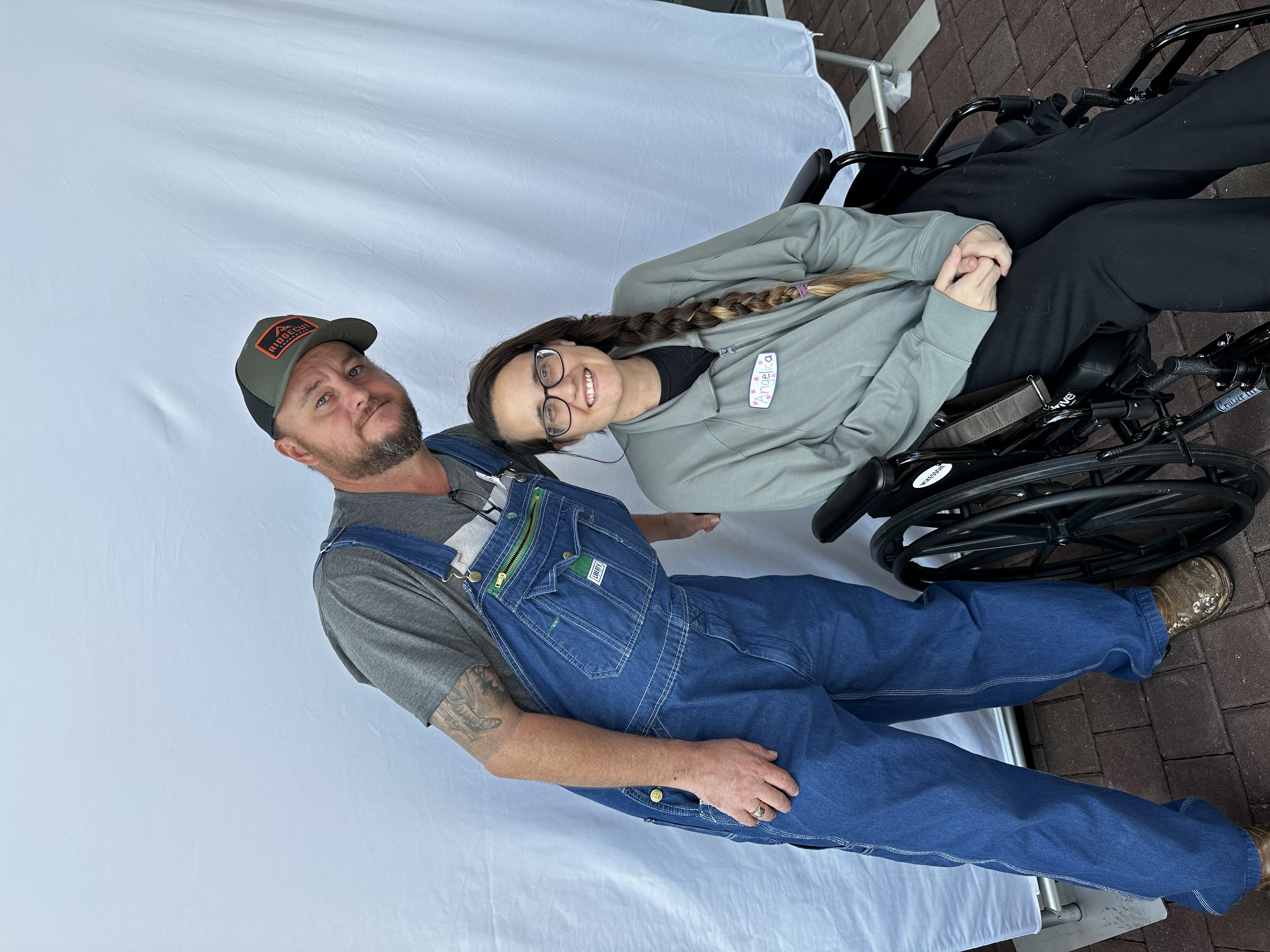 Angelica in a wheelchair with her husband at TriStar Centennial's ECMO Survivor's Reunion.