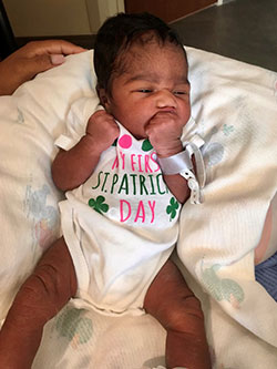 Newborn wearing "My First St. Patrick's Day" shirt.