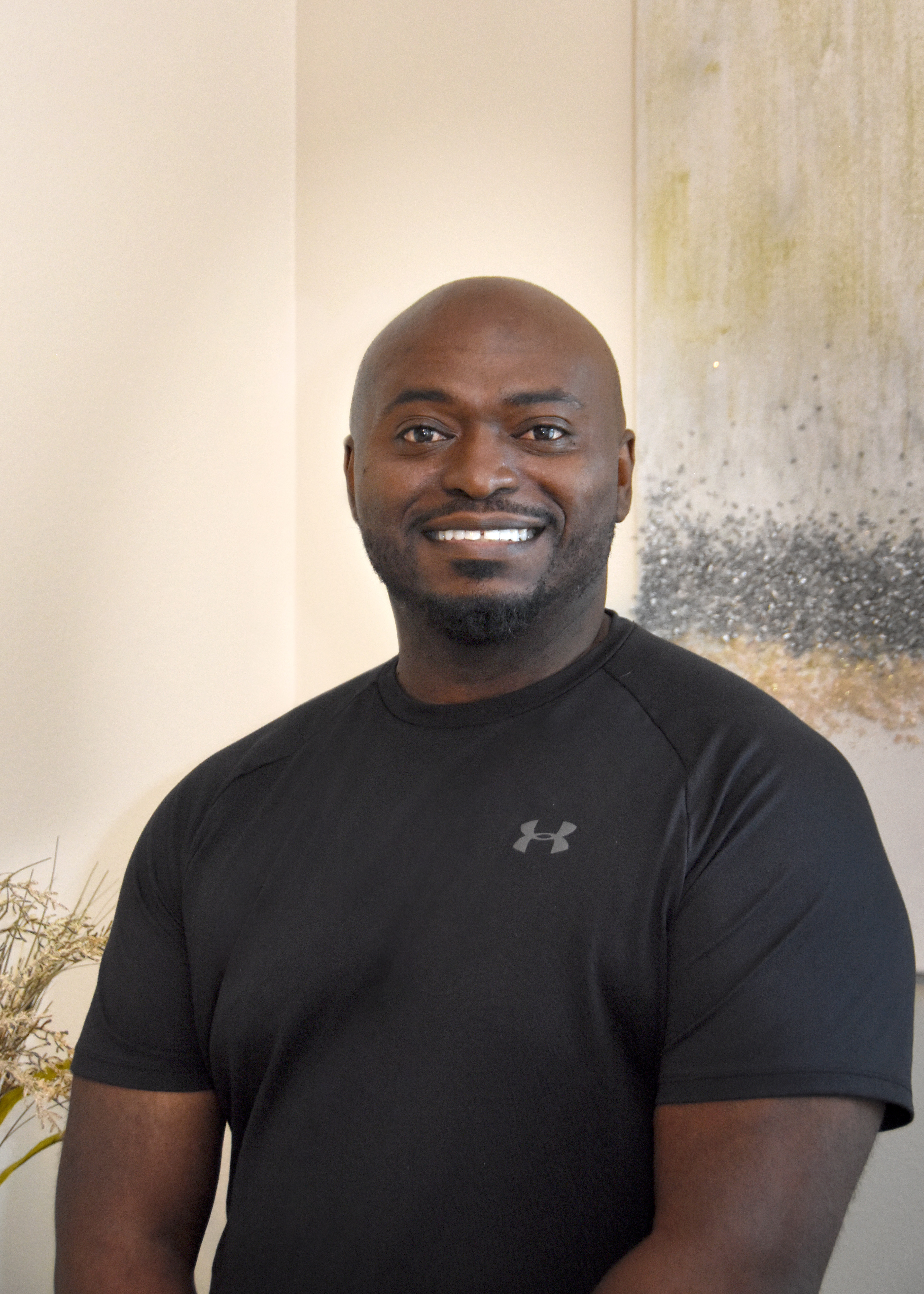 Vaughn Parker smiles while wearing a black athletic t-shirt.