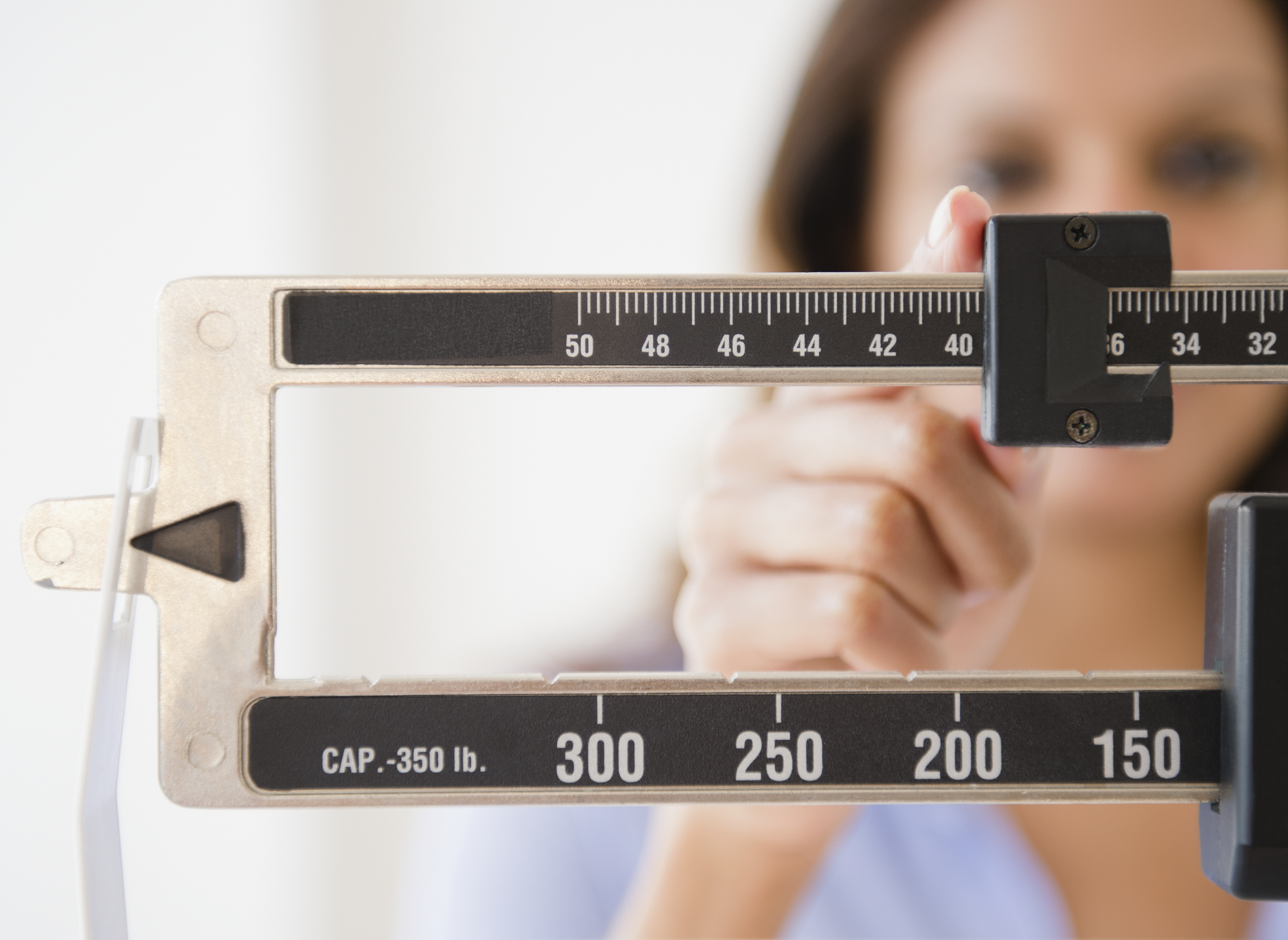 Cape Verdean woman weighing herself - stock photo