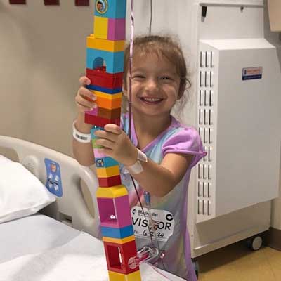 Sophina San Miguel playing with colorful building blocks in a patient room at Methodist Children's Hospital ER.