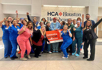 The HCA Healthcare Southeast staff holding a sign that says "Celebrating 100 TCAR Procedures."