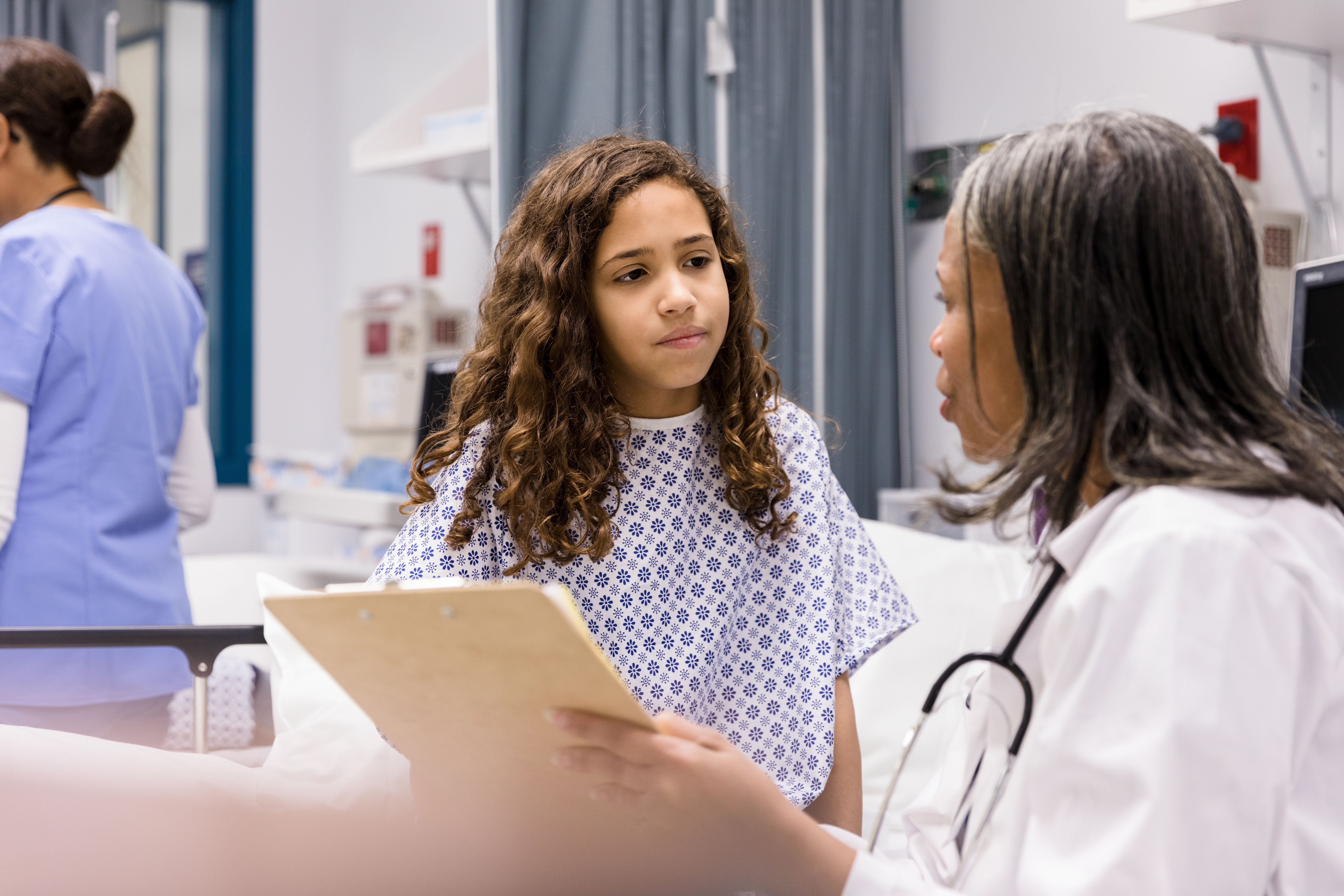 Teen girl listens as doctor explains test results - stock photo
