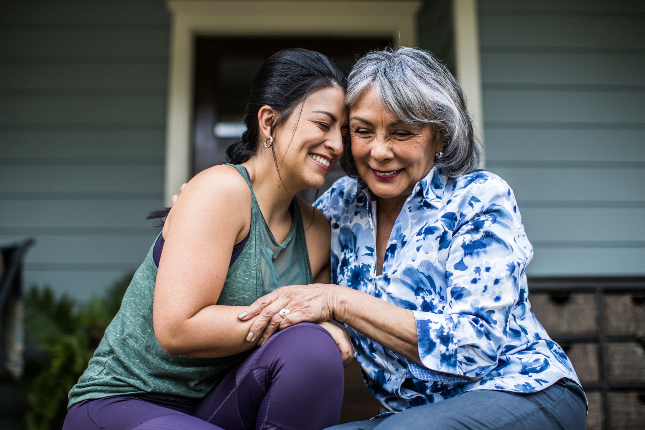 And older and younger lady hugging and smiling