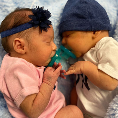 The baby Villegas twins together snuggled together.