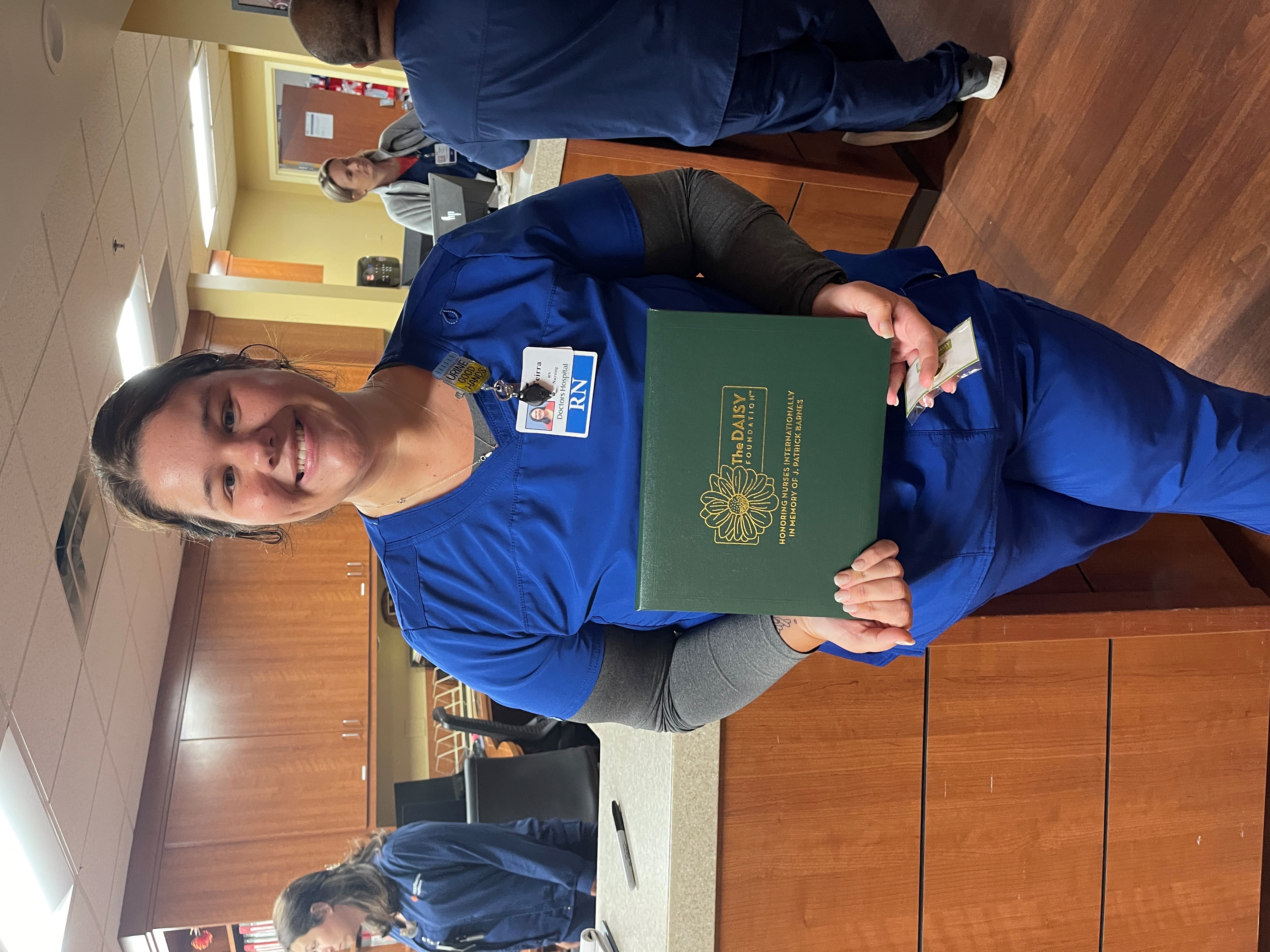 Nurse stands with award smiling