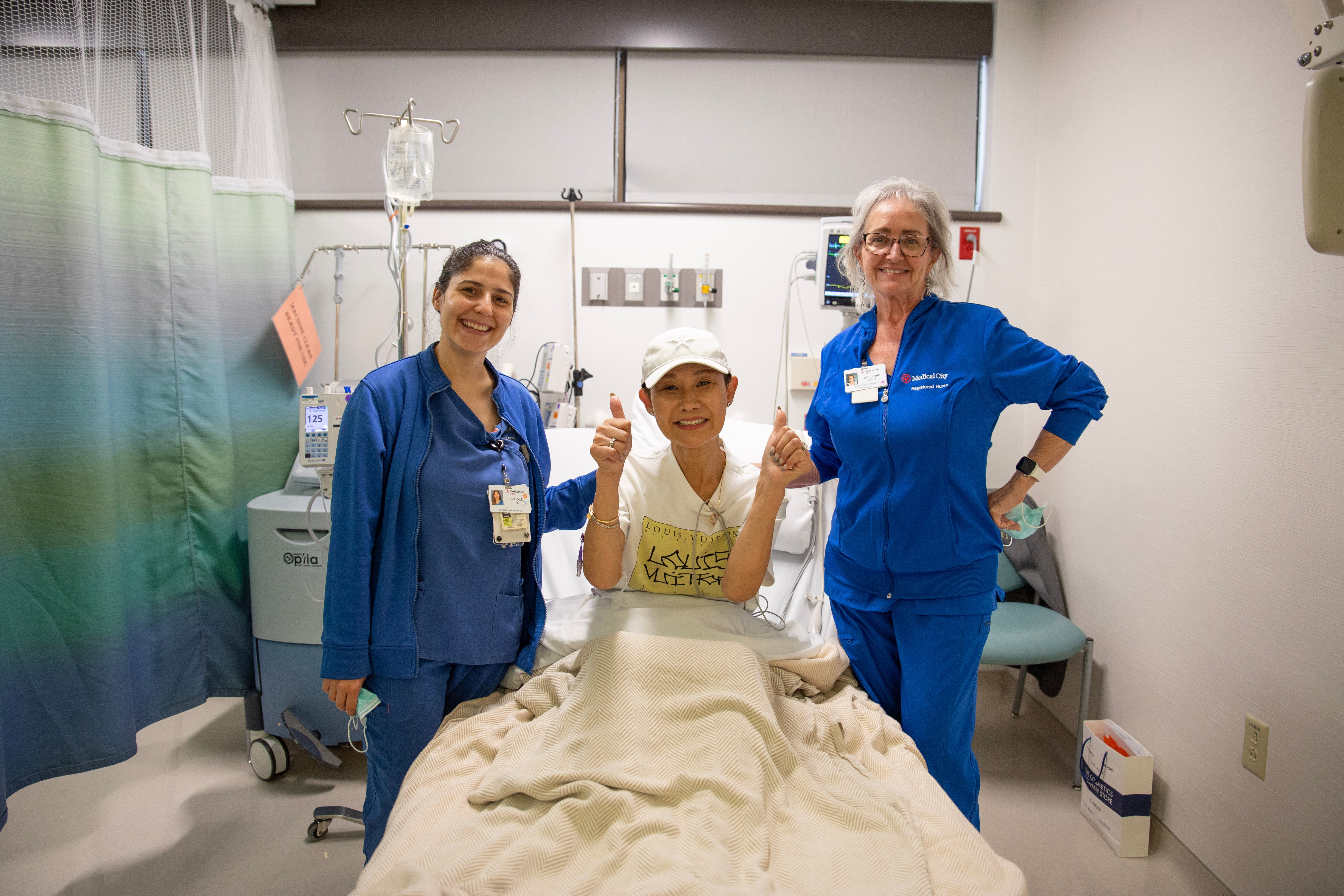 Patient Bo Li smiling with nurses.