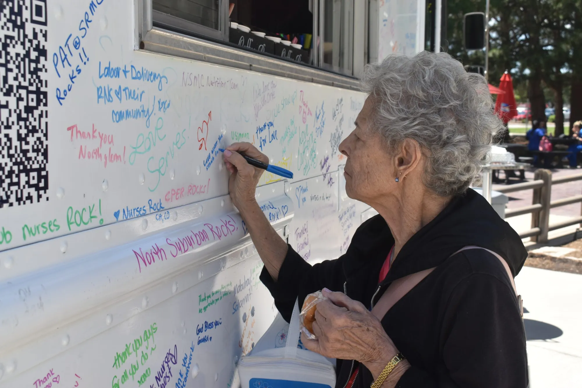 A visitor at Centennial Hospital writes a message of gratitude on the HealthONE Show Love Project coffee truck July 3,2024.