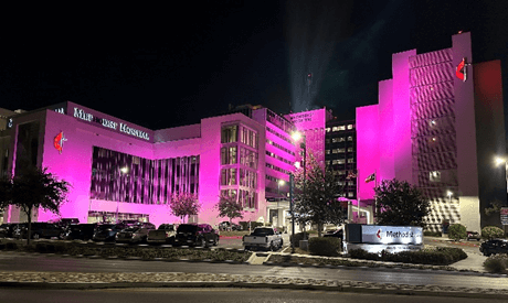 The outside facade of Methodist Hospital covered in a pink light.