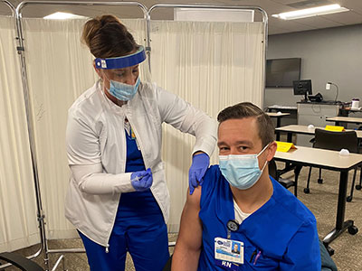 Garin Knutson, RN, Intensive Care Unit, Brandon Regional Hospital, receives the first COVID-19 vaccination for HCA Healthcare West Florida.