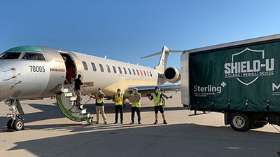 A crew from Bombardier Aviation unloads donated PPE from a jet.