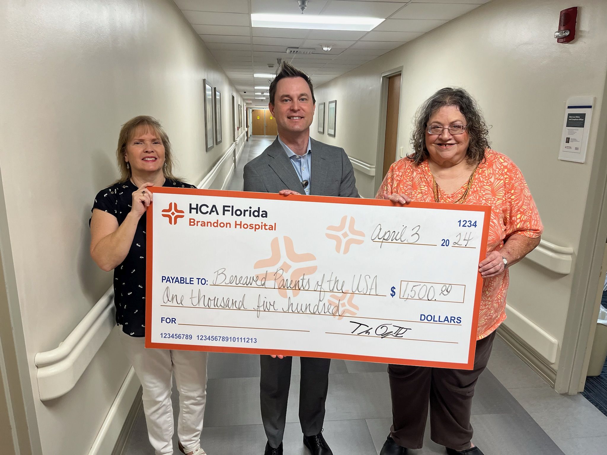 Tripp Owings, CEO of HCA Florida Brandon Hospital presents $1,500 check to leaders of Bereaved Parents USA Tampa Bay.