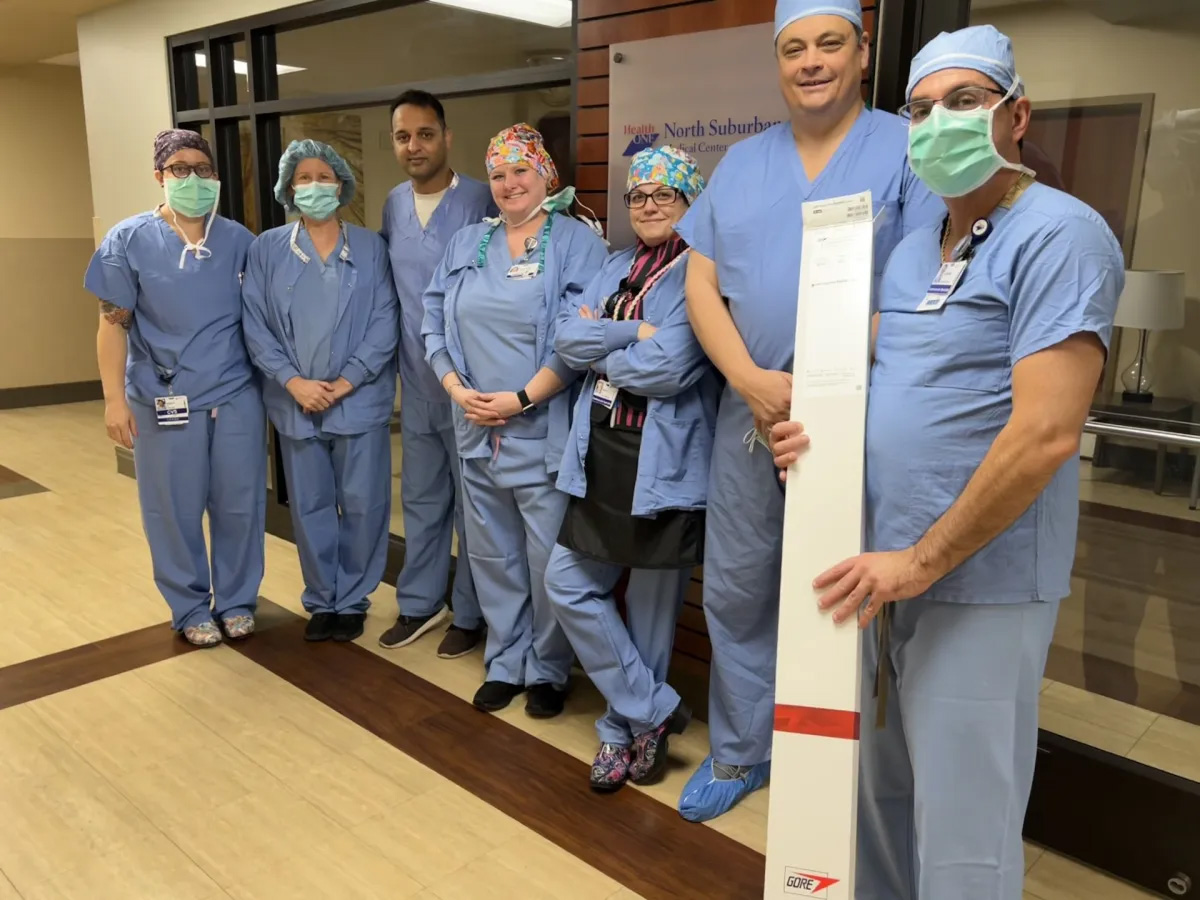 North Suburban Medical Center team that repaired Craig McCormack's heart included from left, RN Sara Pickard, RN Mary Foley, Dr. Qaiser Khan, RN Chantal Anderson, RN Katie Kadinger, Dr. Ehrin Armstrong, and cardiovascular invasive specialist Jason Staple. The white box contains equipment used in the procedure.